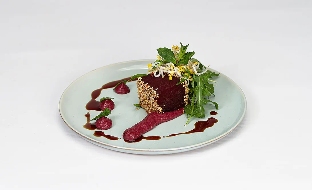 „Fein angerichtetes Gourmetgericht mit Rote-Bete, Sesamkruste und Kräutern