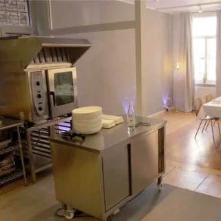 location-kueche-essbereich Moderner Küchenbereich mit Edelstahlmöbeln und angrenzendem Essraum