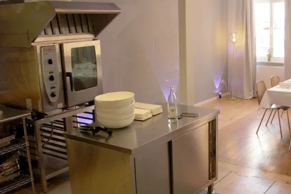 Moderner Küchenbereich mit Edelstahlmöbeln und angrenzendem Essraum