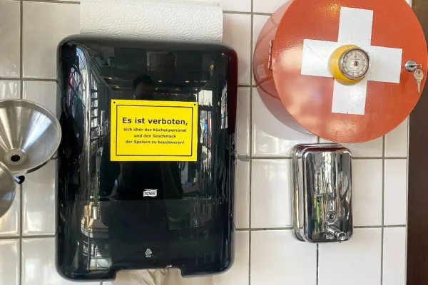 Papierhandtuchspender mit lustigem Küchenschild und Erste-Hilfe-Kasten