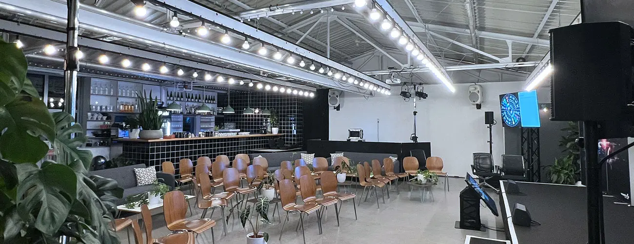 KETAO Eventlocation mit Konferenzbestuhlung, Bühne und moderner Bar im Hintergrund