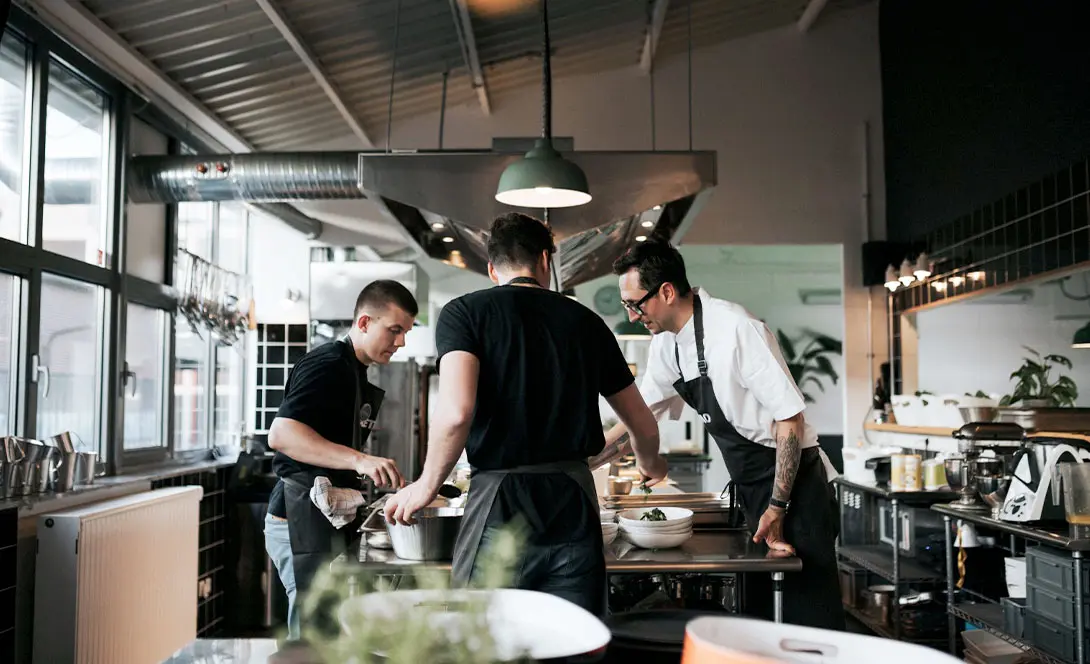 Köche bei der Zubereitung von Speisen in einer modernen Restaurantküche