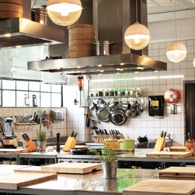 profikueche-edelstahl-kochstation Moderne Profiküche mit Edelstahl-Arbeitsflächen und frischen Kräutern