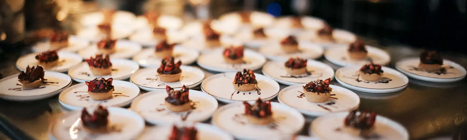 Fein angerichtete kleine Schokoladen-Desserts auf weißen Tellern in moderner Gastronomie