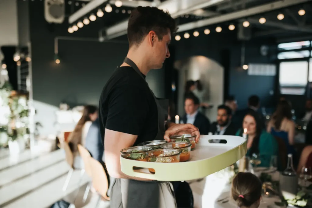 Servicekraft serviert Vorspeisen bei einem KETAO Event Dinner mit Gästen
