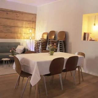 eventraum-gemuetlich-blumen Kleiner Eventraum mit Holzdekor, Stühlen und Sofa