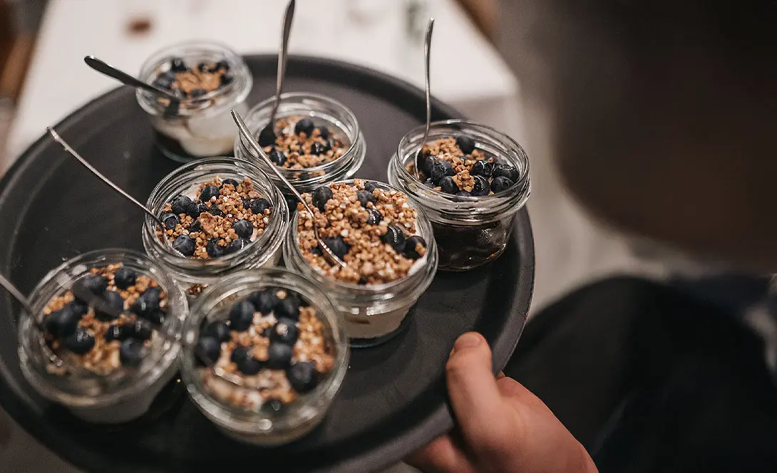 Kleine Dessertgläser mit frischen Blaubeeren und Crunch-Topping