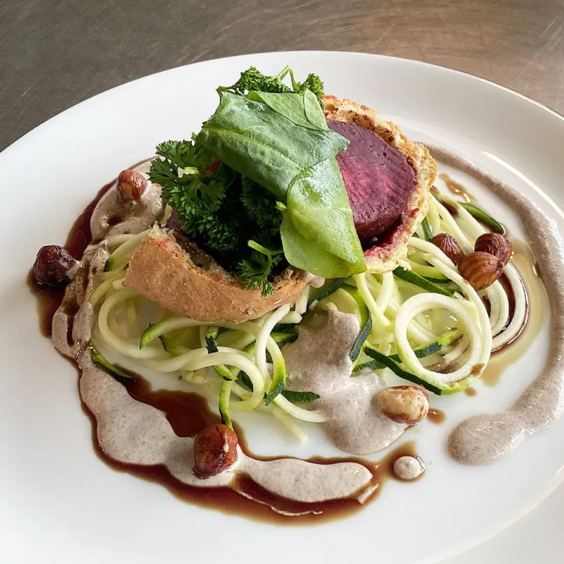 Fein angerichtetes vegetarisches Gericht mit Rote Bete und Haselnüssen