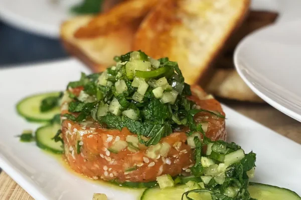 lachstatar-mit-gurken-und-kraeutern Frisches Lachstatar mit Gurkenwürfeln und Rucola, serviert mit geröstetem Brot