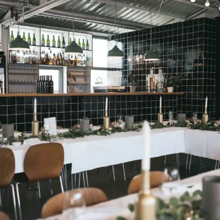 ketao-bar-event Moderne Eventlocation mit Bar, Weinflaschen und eleganter Tischdekoration
