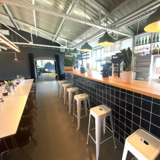 eventlocation-modern-industrial Stilvolle Eventlocation mit Bar mit Pflanzen, Flaschen und gemütlicher Beleuchtung