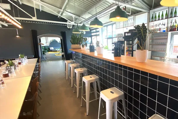 Stilvolle Eventlocation mit Bar mit Pflanzen, Flaschen und gemütlicher Beleuchtung