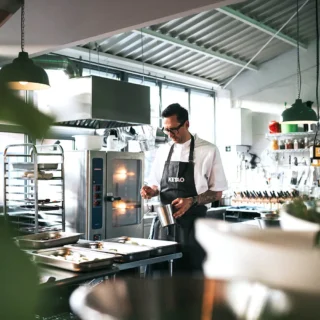 profikoch-eventkueche Koch in moderner Eventküche bei der Zubereitung von Speisen