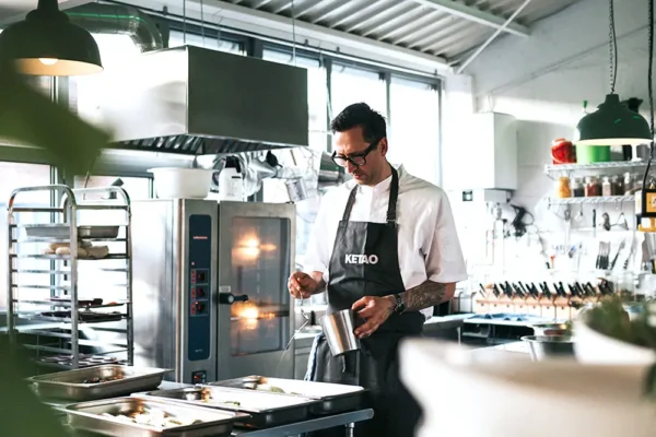 Koch in moderner Eventküche bei der Zubereitung von Speisen