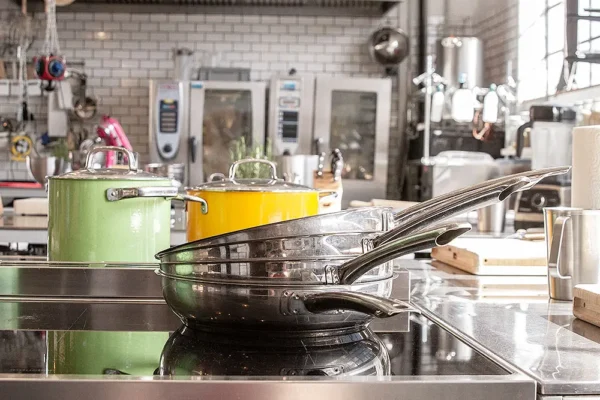 Moderne Kochstation mit Herd, Pfannen und Töpfen
