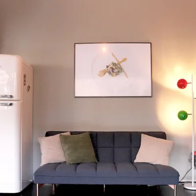 lounge-sofa-retroeinrichtung Gemütliche Sitzecke mit Retro-Kühlschrank und grauem Sofa